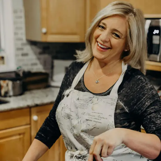 Colleen in an apron in her kitchen.