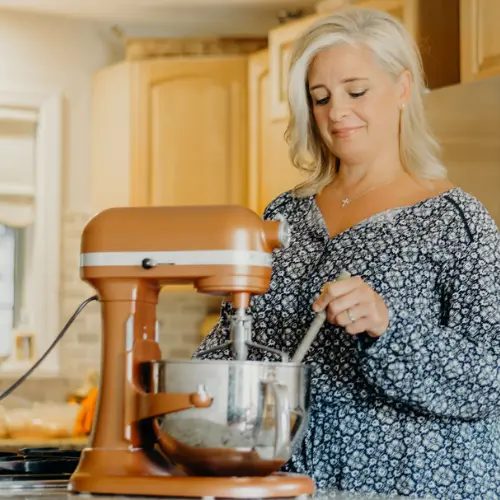 Colleen mixing ingredients with a stand mixer in her kitchen.