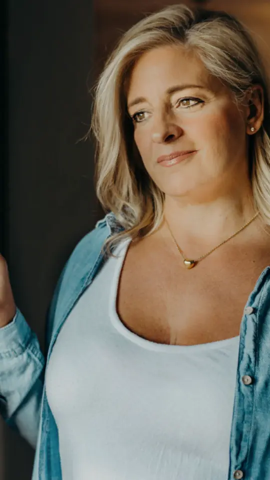 Colleen Walsh, founder of Homemade by Colleen, in a denim shirt by a window.